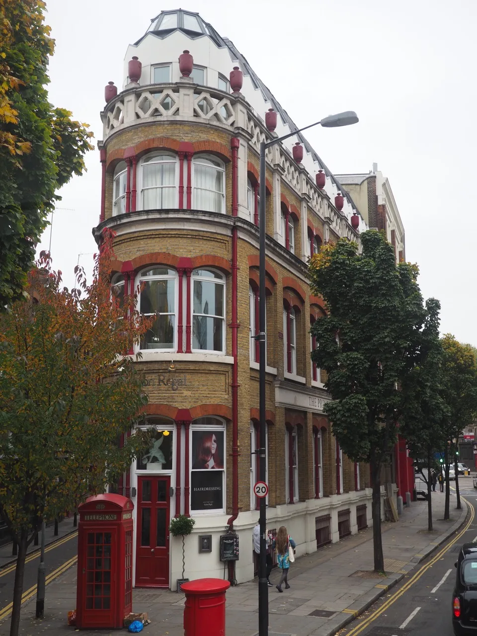 Façade arrondie en briques près d'une cabine téléphonique londonienne