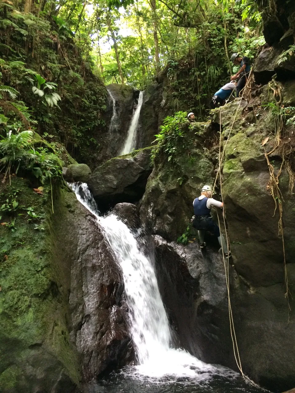 Canyoning en famille au bord d'une cascade de forêt tropicale