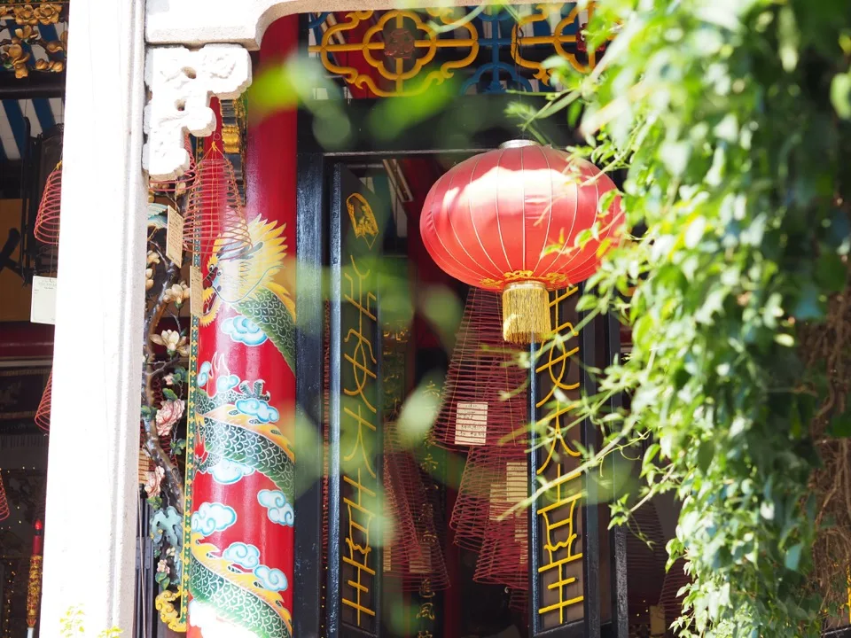 Lanterne rouge suspendue dans une cour colorée de Hoi An