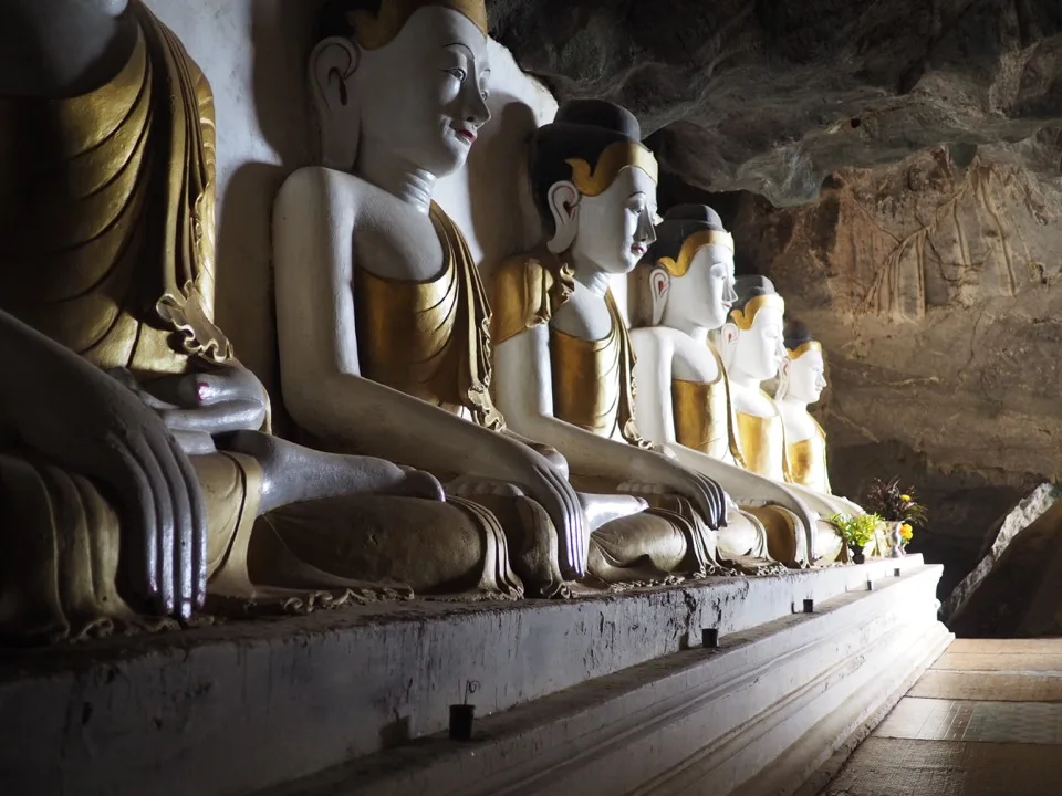 Reihe sitzender Buddha-Statuen in einer Kalksteinhöhle