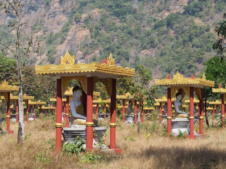 Sanctuaires de Bouddha colorés dans un champ sous des collines calcaires