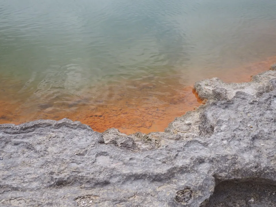 Orangefarbener Mineralrand einer Thermalquelle in Rotorua