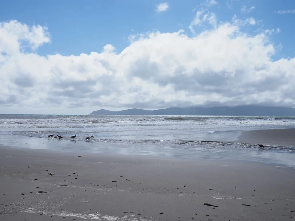 Lake Taupo unter Wolken mit Vulkanen am Horizont
