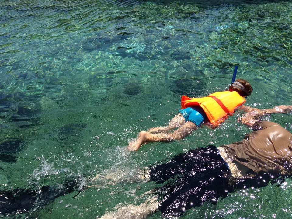 Famille pratiquant le snorkeling dans une mer turquoise