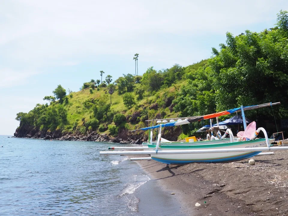 Traditional boat on a volcanic beach in Bali