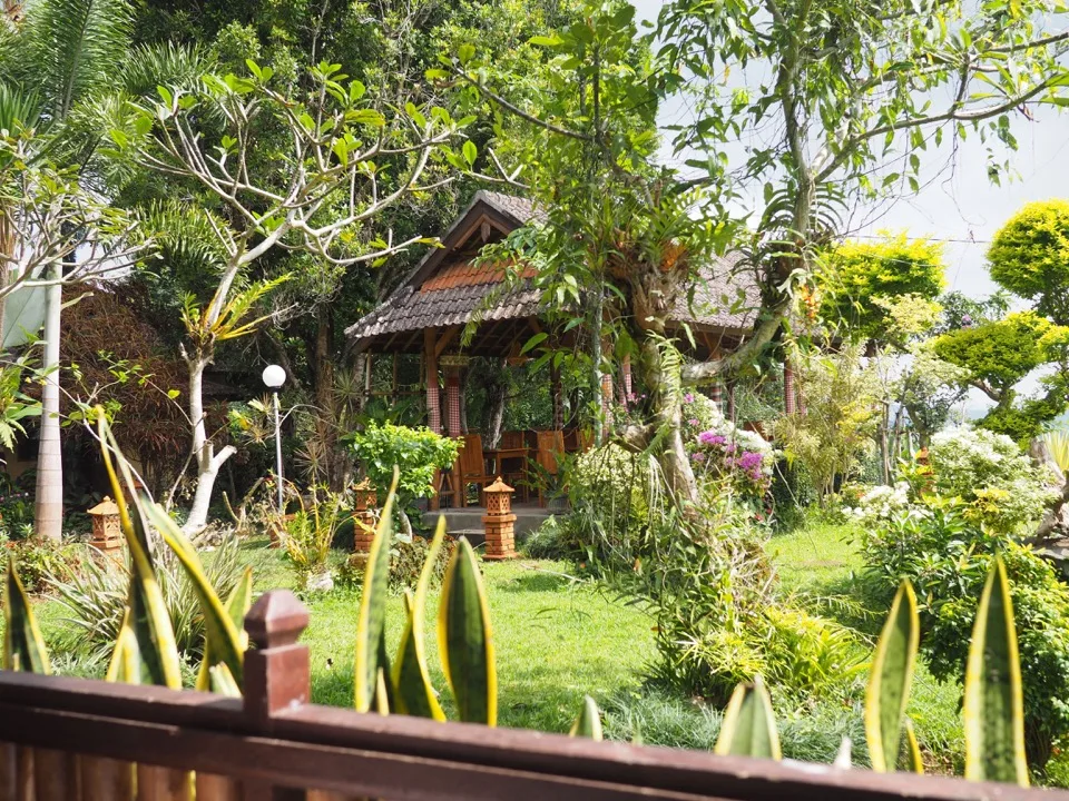 Jardin tropical fleuri autour d'une maison balinaise