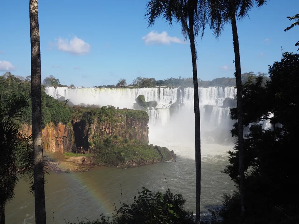 Chutes d'Iguazú encadrées de palmiers et d'un arc-en-ciel