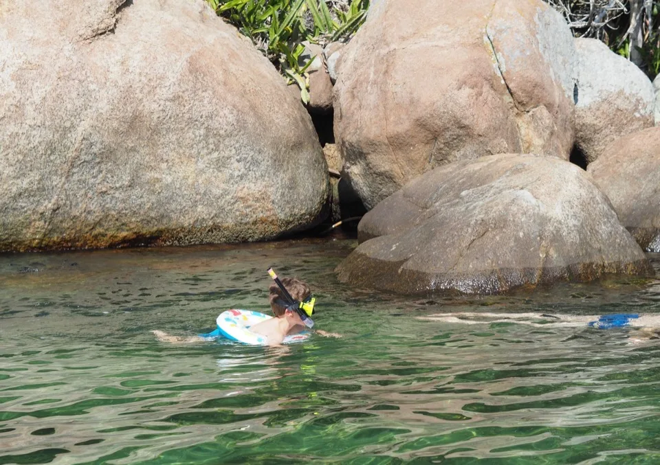 Famille faisant du snorkeling près de rochers