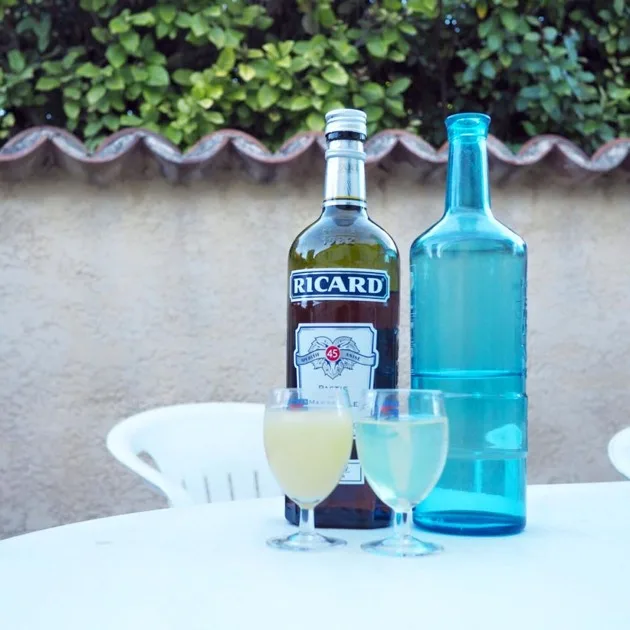 Pastisflaschen und Glas auf einem Tisch