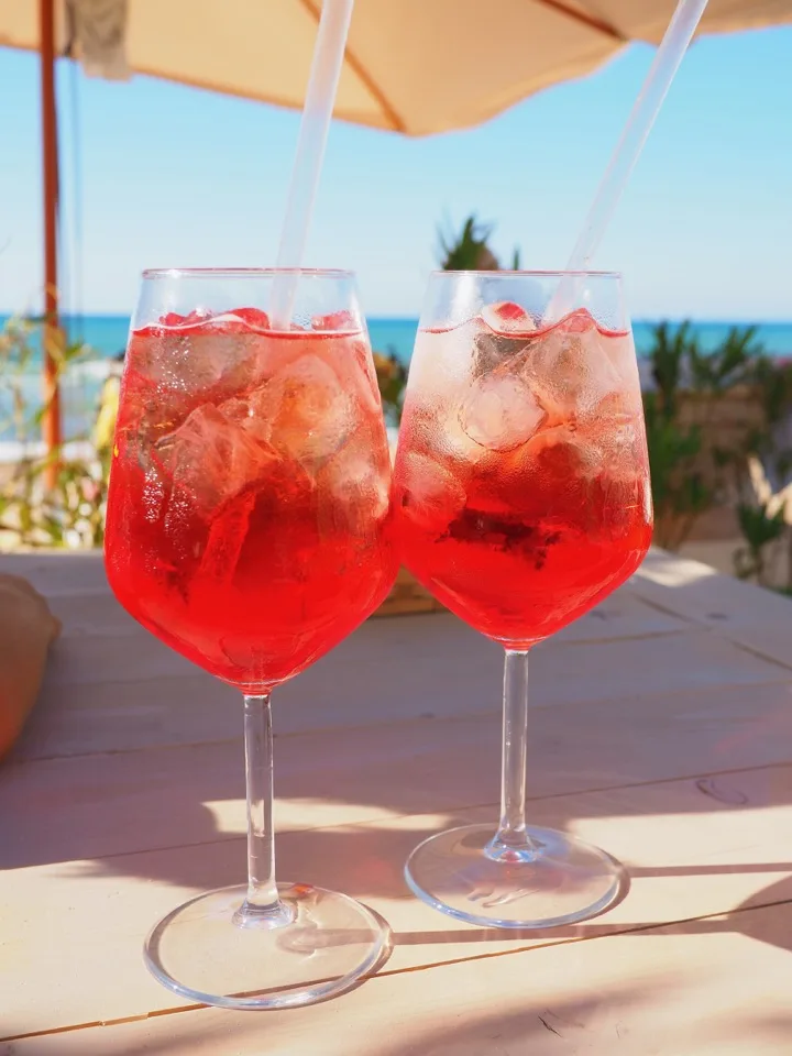 Deux verres de spritz sur une terrasse face à la mer