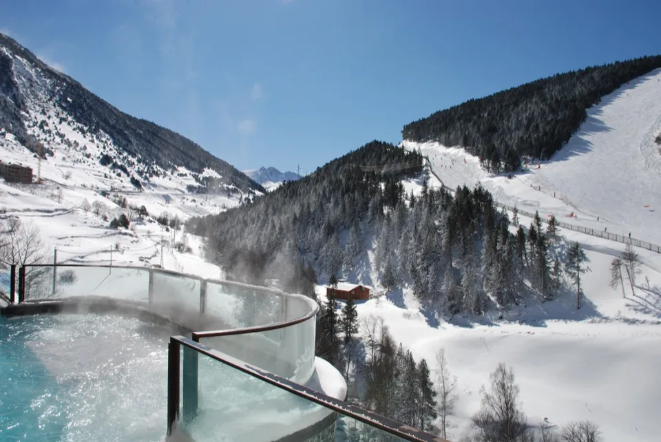Piscine thermale extérieure donnant sur les pistes de ski enneigées d'Andorre