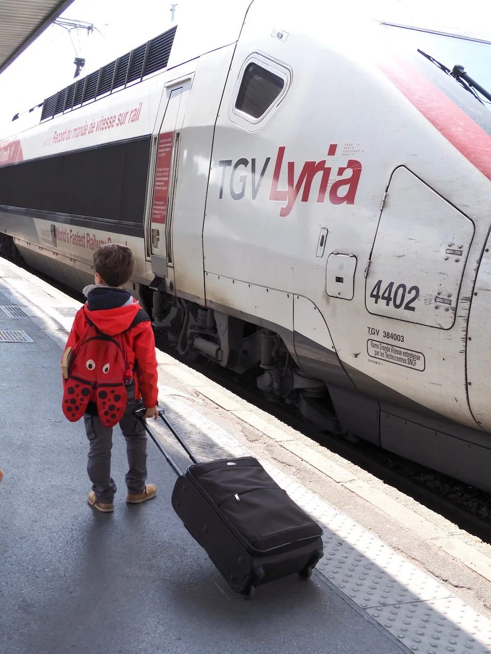 Famille attendant à côté d’un TGV Lyria