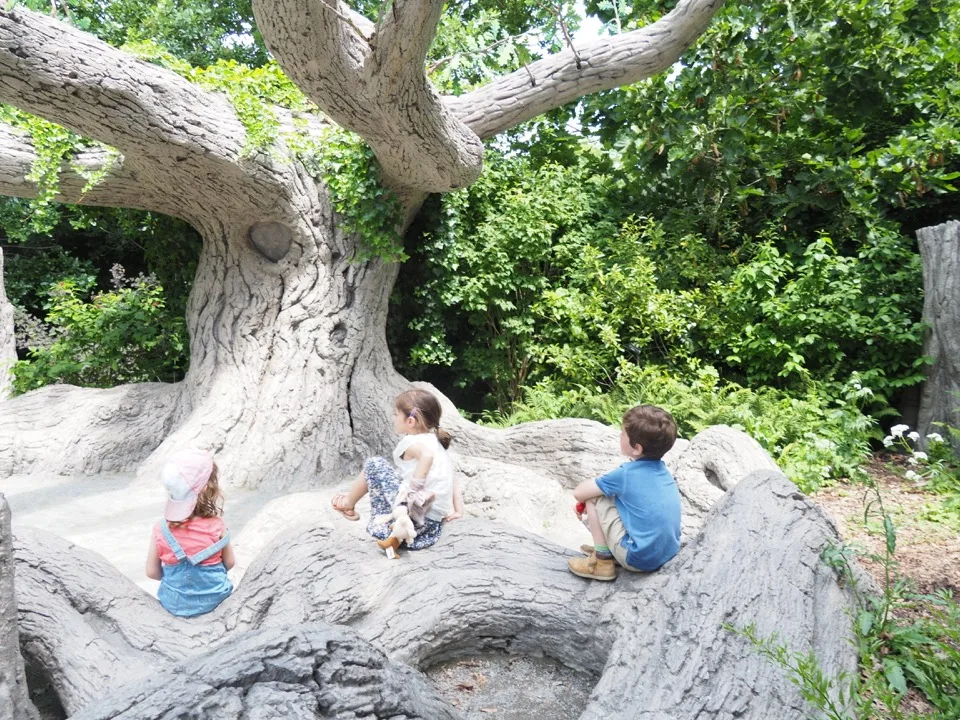 Famille assise sur les racines d'un grand arbre