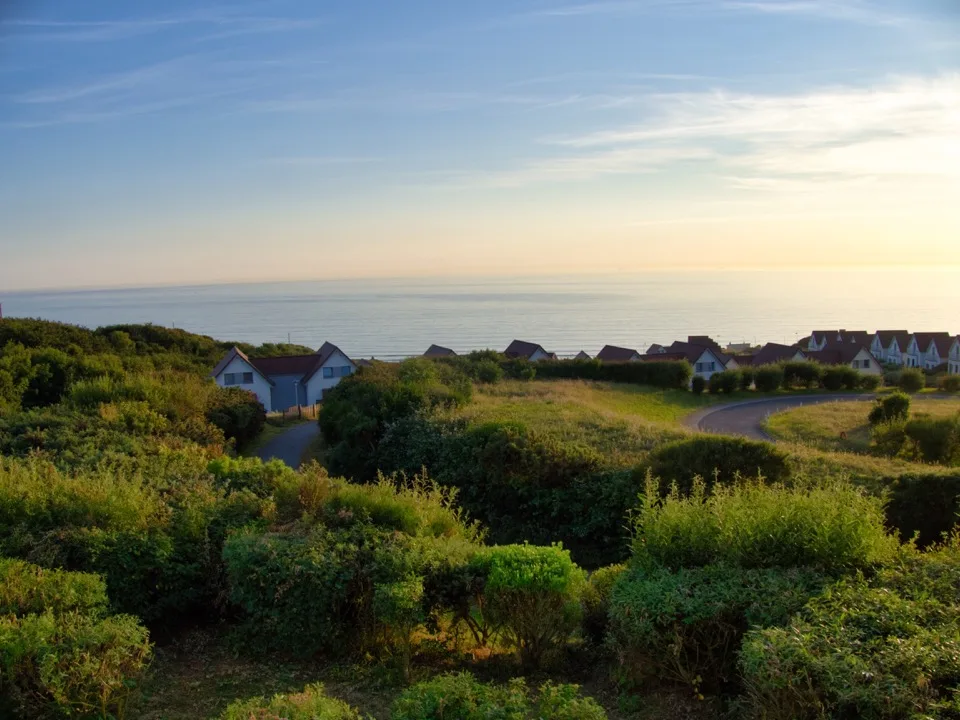 Maisons de vacances derrière les dunes au coucher du soleil