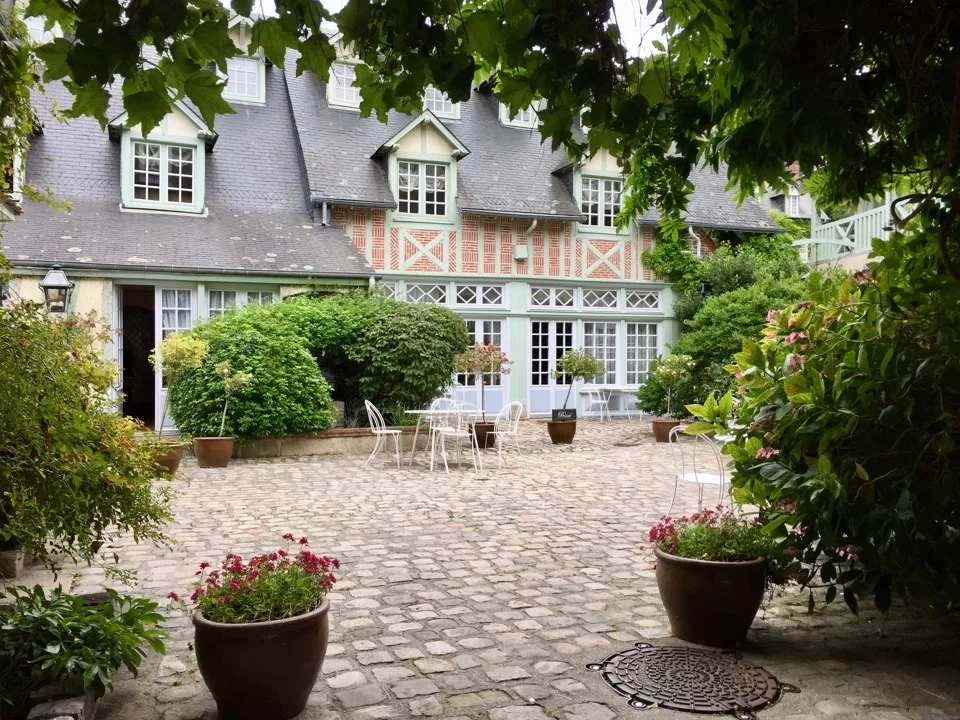 Cour fleurie à côté d'une maison à colombages