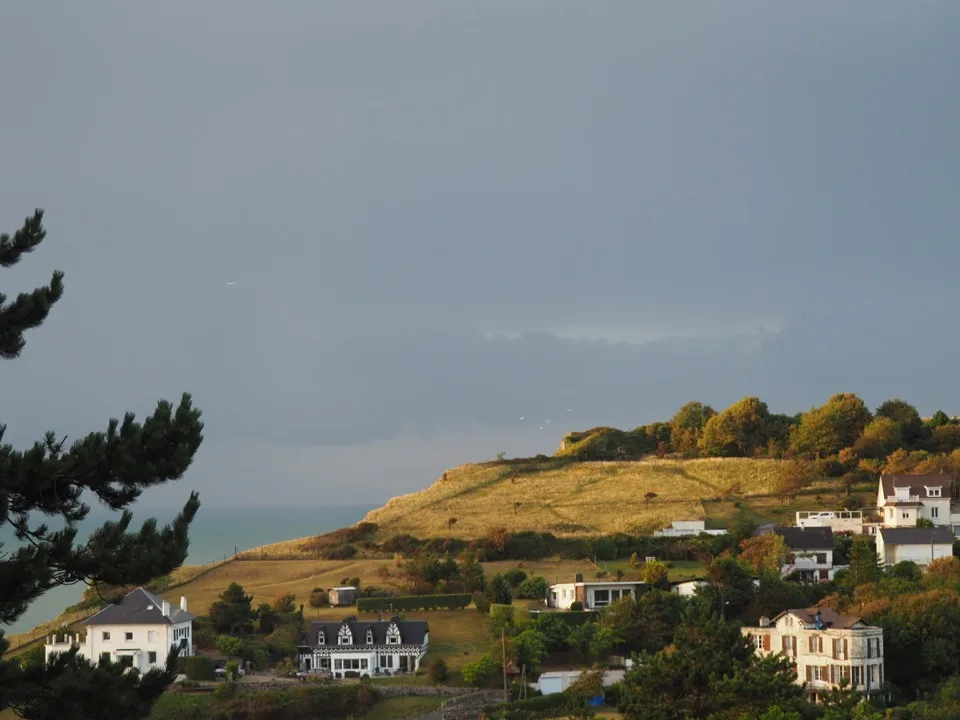 Maisons à flanc de colline sous un nuage sombre à Veules-les-Roses