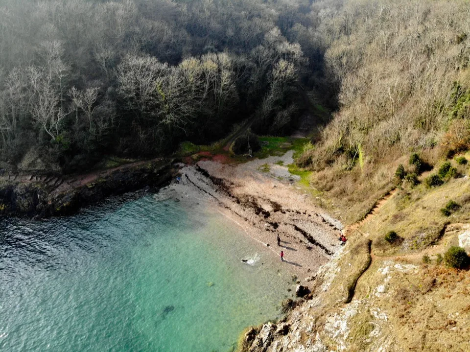 Aerial view of a turquoise cove on the Devon coast