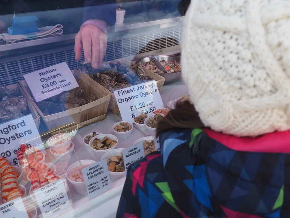 Famille choisissant des huîtres dans un stand de fruits de mer de Brighton