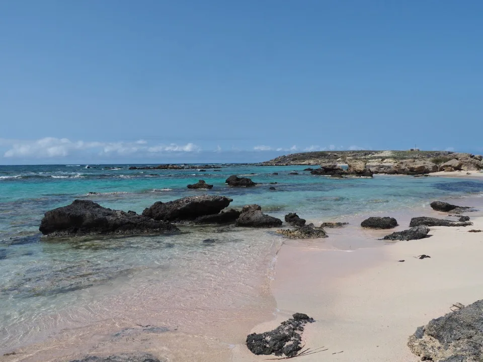 Black rocks in the clear water at Elafonissi beach