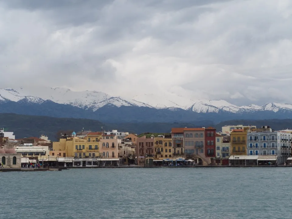 View of Chania’s Venetian harbour with snow-capped mountains