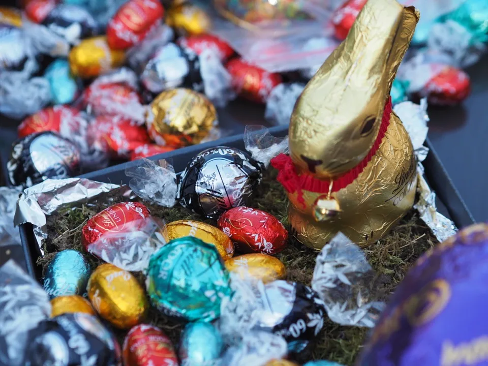 Des œufs en chocolat et un lapin en feuille d'or disposés pour Pâques