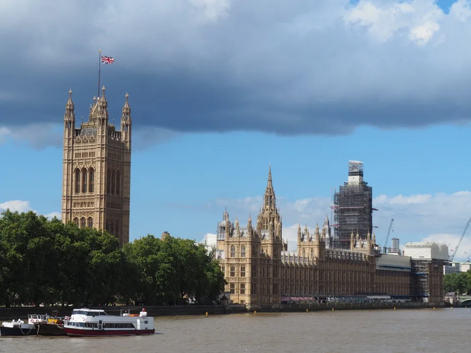 Palais de Westminster vu depuis la Tamise sous un ciel nuageux