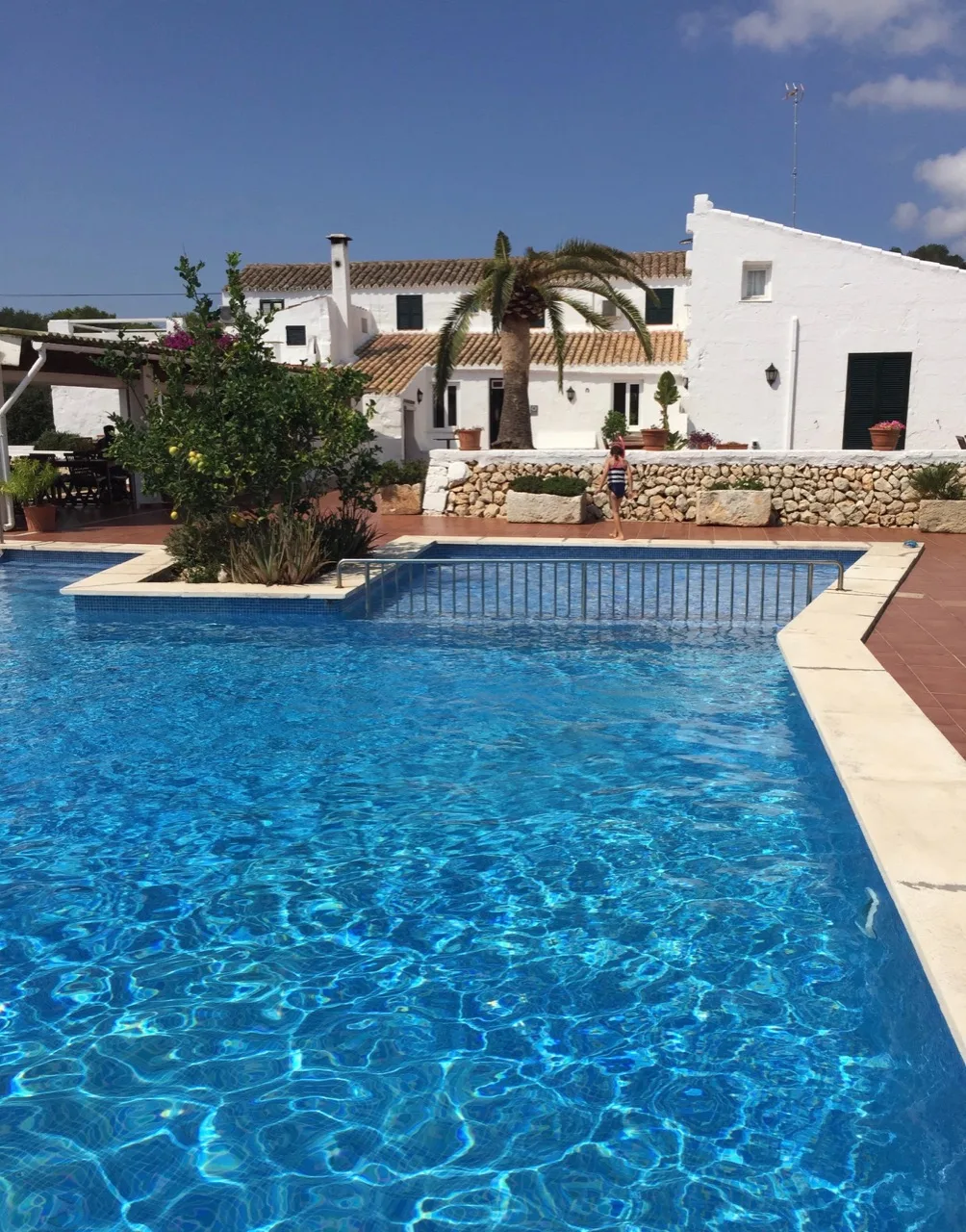 Pool vor den weißen Gebäuden des Agriturismo Binissafullet