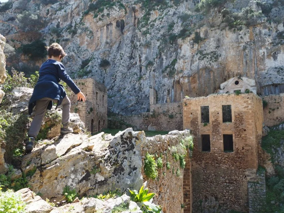 Family seen from behind beside a chapel on a Cretan trail