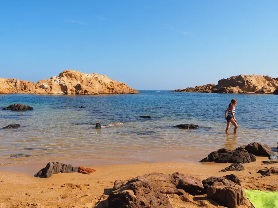 Goldener Sand und felsige Inselchen in der Cala Pregonda