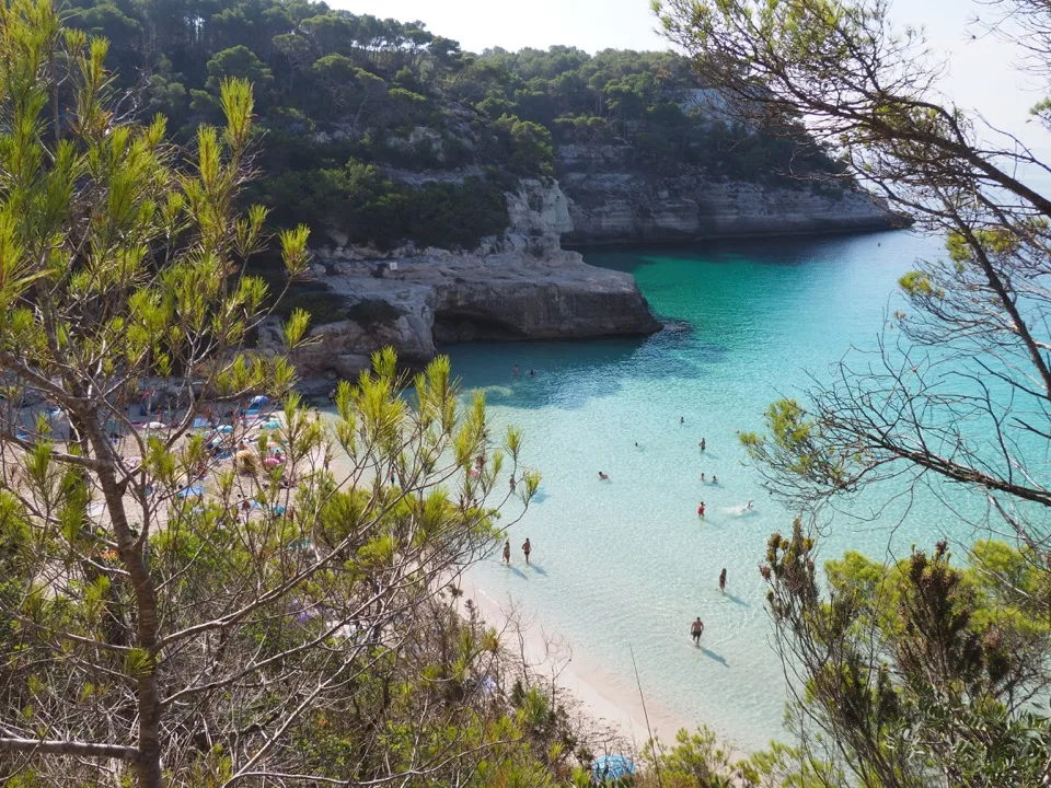 Cala Mitjana mit weißem Sandstrand zwischen Pinien