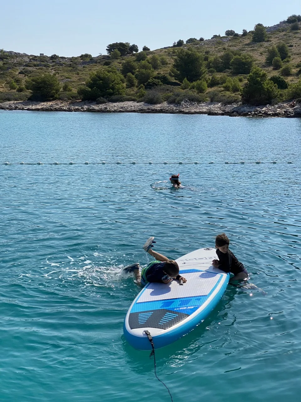 Stand-up-Paddleboard im türkisfarbenen Wasser einer kroatischen Bucht