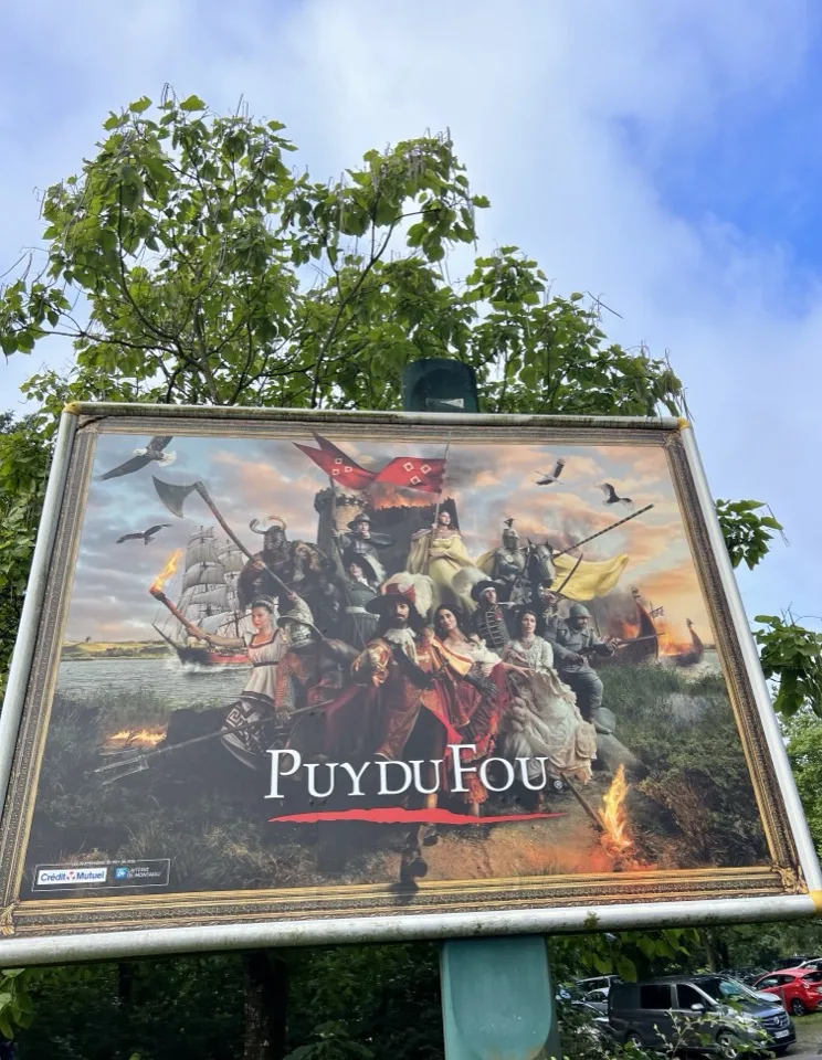 Affiche du Puy du Fou au bord d'un chemin