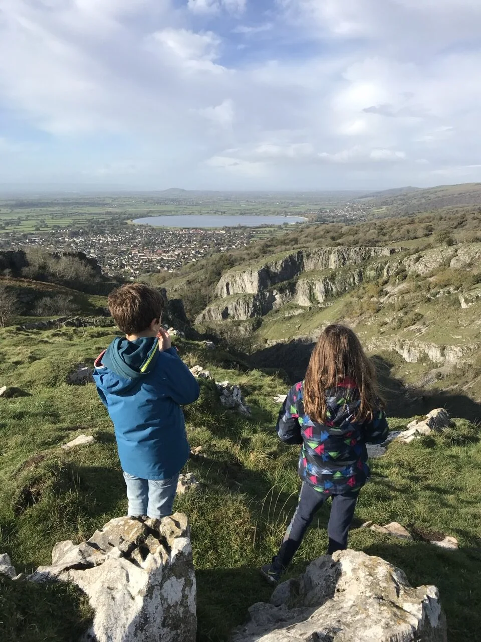 Deux enfants vus de dos face aux gorges de Cheddar et au réservoir